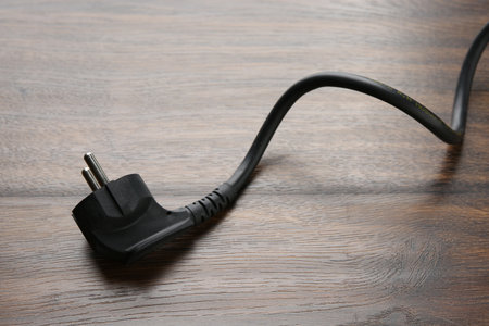 Electrical wire with plug on wooden table, closeupの写真素材
