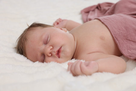 Cute newborn baby sleeping on bed, closeup