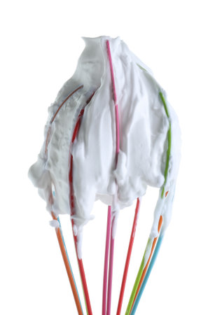 Whisk with whipped egg whites isolated on whiteの写真素材