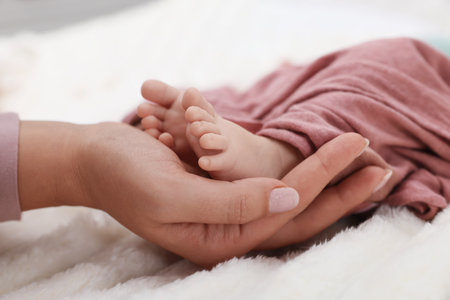 Mother with her newborn baby on bed, closeupの写真素材