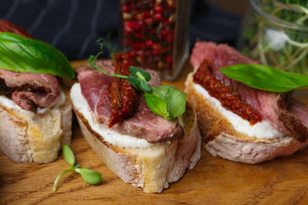 Bruschettas with roast beef served on table, closeup