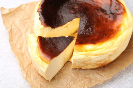 Cut Basque cheesecake on light gray textured table, closeupの写真素材