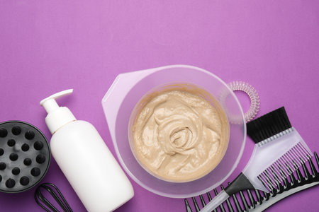 Professional tools and products for hair dyeing on purple background, flat layの写真素材