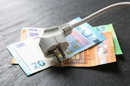 Electrical wire with plug and euro banknotes on black table, closeupの写真素材