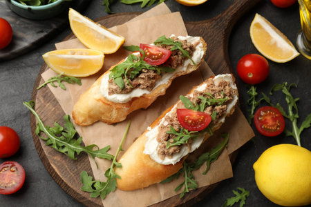 Delicious bruschettas with tuna, tomatoes, arugula and lemons on gray table, flat layの写真素材