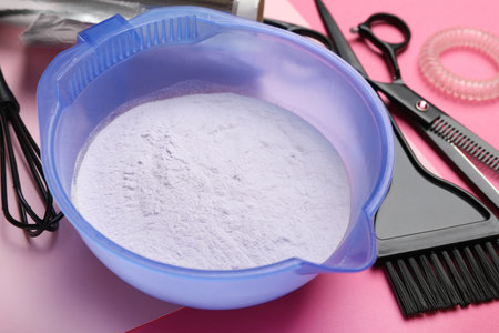 Hair dye in bowl and hairdresser's tools on pink background, closeupの写真素材