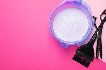 Hair dye in bowl, brush and scissors on color background, flat lay. Space for textの写真素材