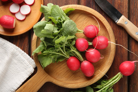 Fresh ripe radishes and knife on wooden table, flat layの写真素材