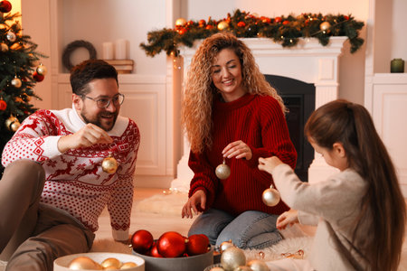 Happy family with ornaments near Christmas tree at homeの写真素材