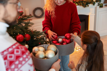 Happy family decorating Christmas tree at home, closeupの写真素材