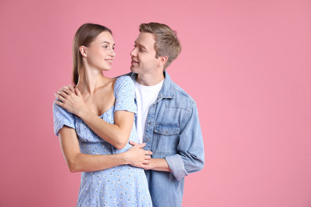 Lovely couple hugging on pink background, space for text. Romantic dateの写真素材