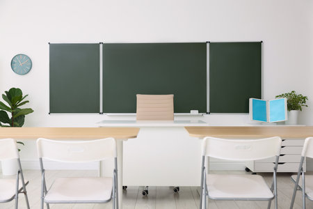 Green board and stylish furniture in classroom. Mockup for designの写真素材
