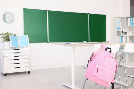Green chalkboard and stylish furniture in classroom. Mockup for designの写真素材