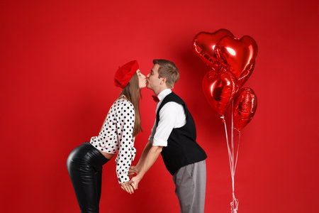 Cute couple kissing on red background. Romantic dateの写真素材