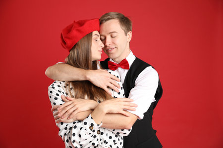 Beautiful couple hugging on red background. Romantic dateの写真素材