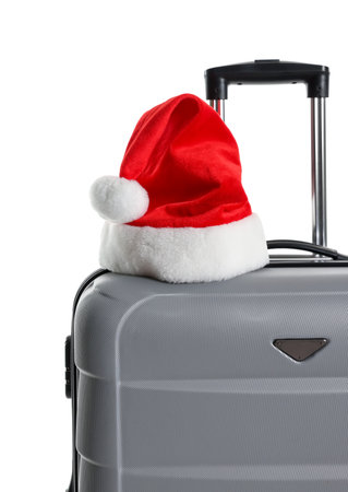 Stylish gray suitcase with Santa hat isolated on white. Christmas vacationの写真素材