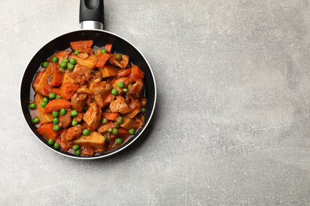 Delicious cooked stew in frying pan on gray table, top view. Space for textの写真素材