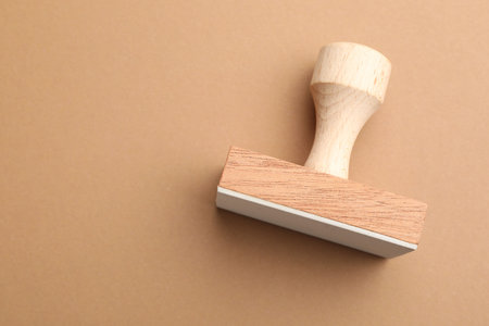 One wooden stamp on brown background, top view. Space for textの写真素材