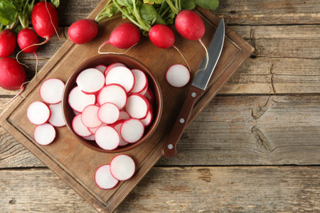 Fresh ripe radishes and knife on wooden table, flat lay. Space for textの写真素材