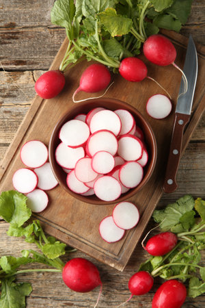 Fresh ripe radishes and knife on wooden table, flat layの写真素材