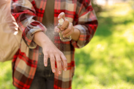 Woman spraying tick repellent onto hand in park, closeupの写真素材