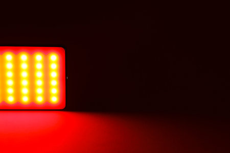LED lamp glowing with red light on dark background, closeupの写真素材