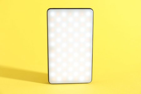 One stylish LED lamp on yellow background, closeup