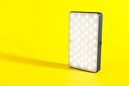 One stylish LED lamp on yellow background. Space for textの写真素材