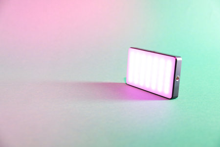 Modern glowing LED lamp on color background. Space for textの写真素材