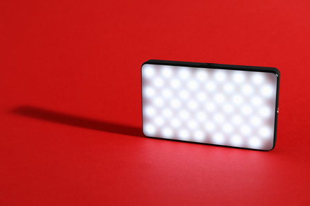 LED lamp on red background, closeup. Space for textの写真素材