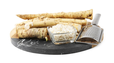 Whole and grated horseradish roots near graterの写真素材