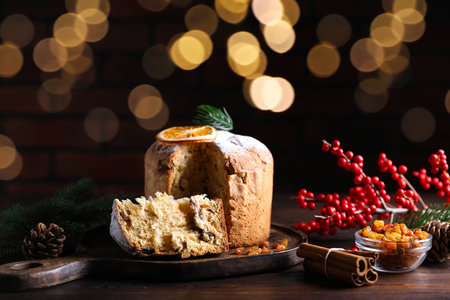 Christmas food. Delicious Panettone cake and festive decor on wooden table, closeupの写真素材