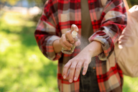 Woman spraying tick repellent onto hand in park, closeupの写真素材