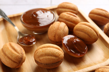 Nut shaped cookies with condensed milk on white table, closeupの写真素材