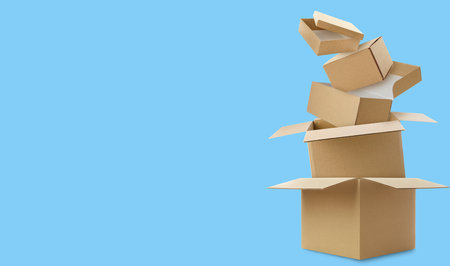 Cardboard boxes in air on light blue background. Banner design with space for textの写真素材