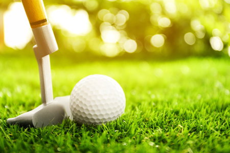 Hitting golf ball with club on green course outdoorsの写真素材