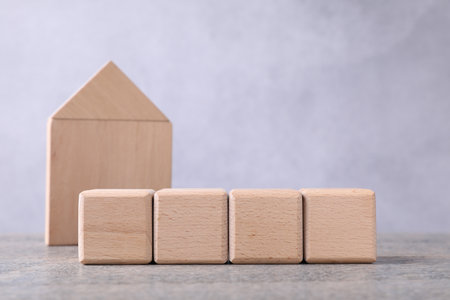 Blank cubes and house model on wooden table. Mockup for designの写真素材