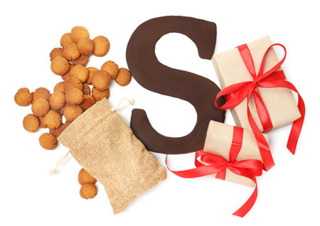 Saint Nicholas (Sinterklaas) day. Chocolate letter S, kruidnoten cookies and gift boxes isolated on white, top viewの写真素材