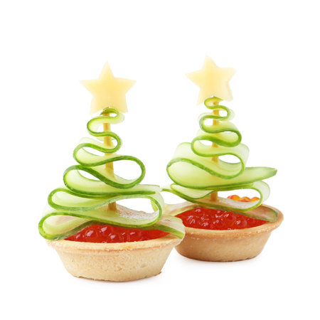 Christmas tree shaped tartlets made with red caviar, cucumber and cheese isolated on whiteの写真素材