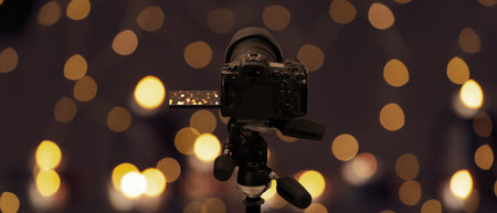 Professional camera against blurred background with bokeh lights. Banner designの写真素材