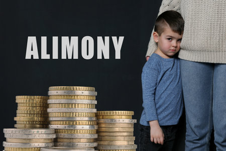 Sad little boy hugging his mother on dark background and stacked coins.の写真素材