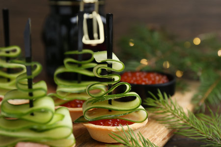 Christmas trees made with cucumber, red caviar, ham and festive decor on table, closeupの写真素材