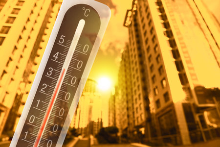 Thermometer showing high temperature, double exposure with city street during hot dayの写真素材