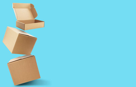 Cardboard boxes in air on light blue background. Banner design with space for textの写真素材