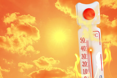 Thermometer with high temperature and flames against orange sky with bright sun and clouds. Extremely hot weatherの写真素材