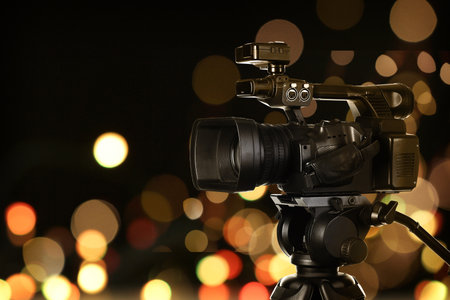 Video camera against blurred lights on dark background, bokeh effectの写真素材