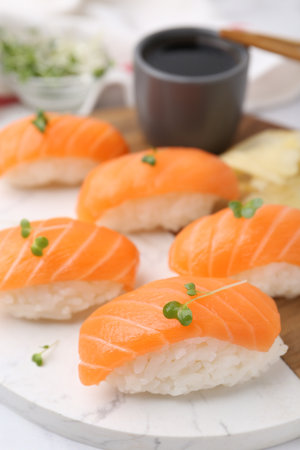 Delicious nigiri sushi with salmon, microgreens and soy sauce on white table, closeupの写真素材