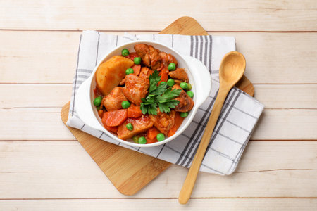 Delicious cooked stew served on light wooden table, flat layの写真素材
