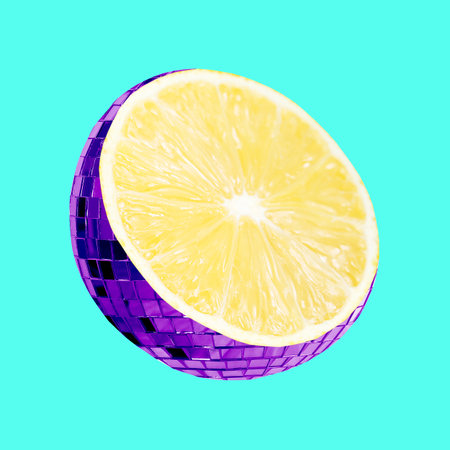 Disco ball with lemon inside on turquoise backgroundの写真素材
