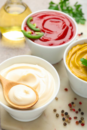 Different sauces, spices and herbs on light table, closeupの写真素材